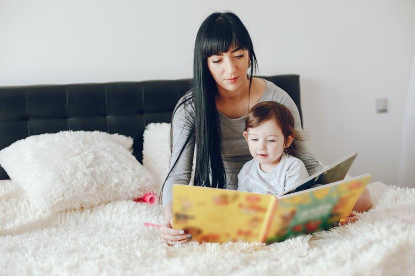 Ibu dan anak membaca buku bersama. Meluangkan waktu membaca bersama anak akan meningkatkan minat baca dan ikatan emosional antara orang tua dan anak.