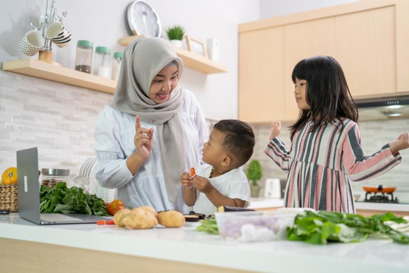 Ibu dan anaknya sedang memasak pada Hari Raya Idul Adha 2023 (ilustrasi).