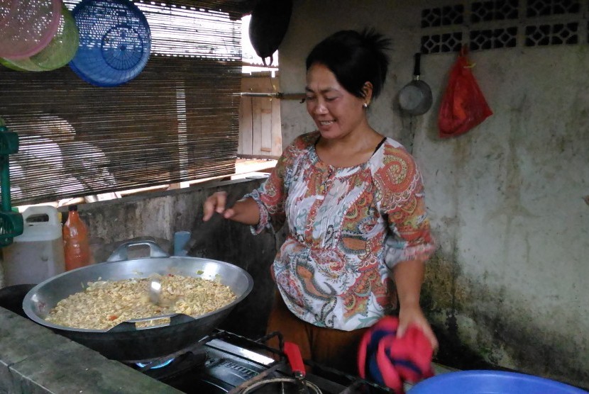 Ibu Jamilah sedang memak makanan untuk pasien sakit jiwa di Yayasan Jamrud Biru