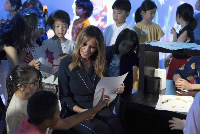  Ibu Negara AS Melania Trump berbincang dengan anak-anak dalam kunjungannya ke musim seni digital di Tokyo, Ahad.