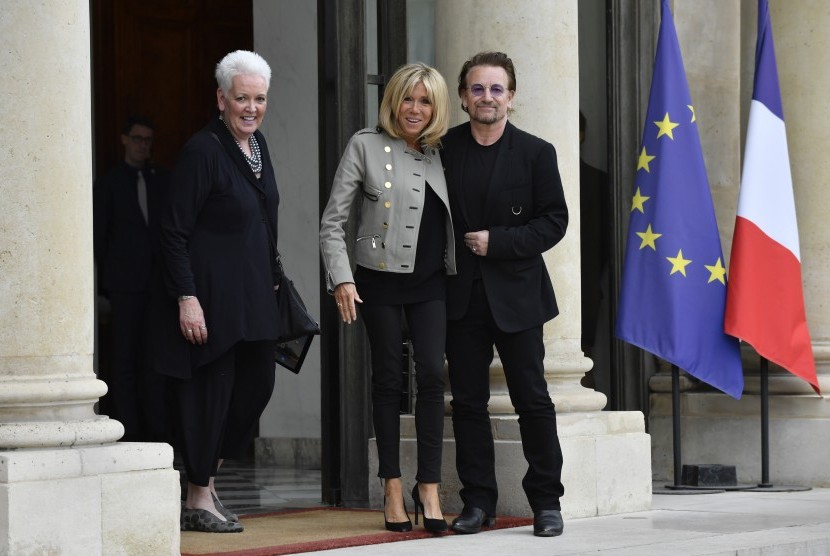 Ibu Negara Prancis Brigitte Macron (tengah) berpose dengan penyanyi rock Bono, (24/7). Bono berada di Istana Elysee Paris untuk bertemu dengan Presiden Prancis Emmanuel Macron.