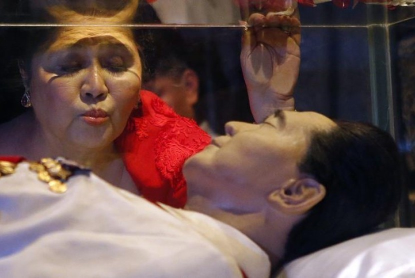 Ibu negara terdahulu Imelda Marcos mencium peti mati kaca berisi jasad suaminya, Presiden Filipina terdahulu Ferdinand Marcos yang belum dimakamkan sejak meninggal pada 1989 di Batac, Provinsi Ilocos Norte, Filipina.