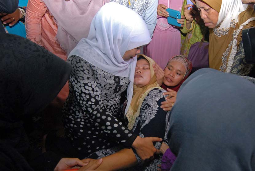 Ibunda dari korban pembunuhan PNF alias Neng, pingsan di pelukan Menteri Sosial Khofifah Indar Parawansa (kiri) usai tahlilan di rumah korban, Rawalele, Kalideres, Jakarta Barat, Rabu (7/10). 
