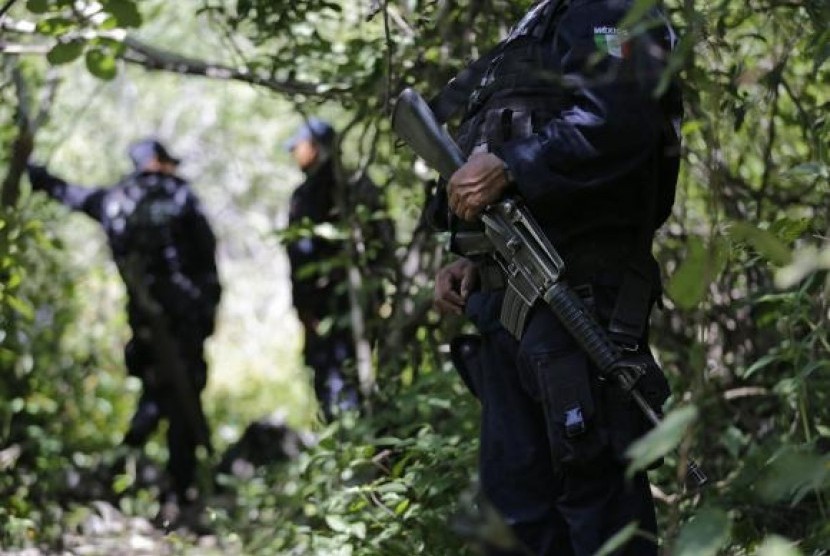 Iguala police officers stand guard at an area near clandestine graves at Pueblo Viejo, in the outskirts of Iguala, southern Mexican state of Guerrero October 9, 2014.