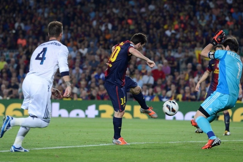 Iker Casillas berusaha menghadang tendangan striker Barcelona Lionel Messi dalam laga El Classico di Nou Camp (7/10)
