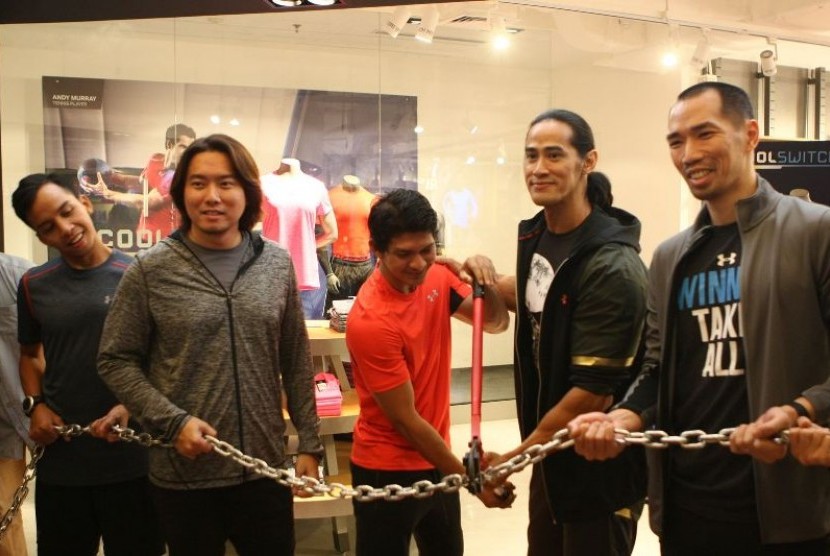 Iko Uwais (tengah) bersama Ade Rai (kedua kanan) secara simbolis memotong rantai tanda pembukaan secara resmi toko Under Armour pertama di Mal Kelapa Gading 3, Jakarta, Sabtu (12/3).