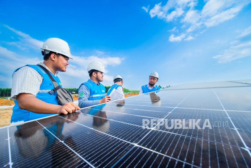Ilustrasi pegawai PLN sedang melakukan inspeksi panel surya PLTS.