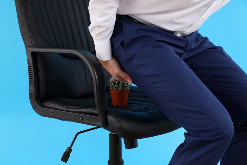 Pria duduk di kursi (Ilustrasi). Hindari duduk dengan dompet tebal di kantong belakang.