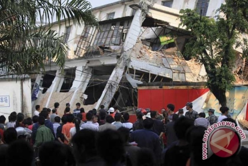 Ilustrasi--Warga berdiri di depan gedung rusak setelah gempa melanda negara bagian Yinjiang, provinsi Yunnan, Kamis (10/3). Gempa berkekuatan 5,8 mengguncang daerah Yingjiang kala itu menyebabkan 25 warga tewas dan 250 lainnya terluka.
