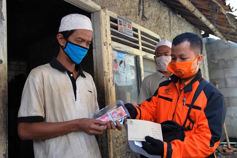 Petugas Pos Indonesia menyerahkan bantuan sosial tunai kepada Keluarga Penerima Manfaat (KPM) di Kampung Pabuaran Cibadak RT 02/03 Kelurahan Cibadak, Tanah Sareal, Kota Bogor, Jawa Barat. (ilustrasi)