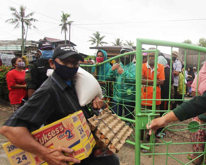 Seorang warga membawa paket sembako bansos (ilustrasi). Kementerian Sosial tengah mengkasi sinergitas antarpihak dalam menangani kemiskinan ekstrem di Bandung, Jawa Barat.