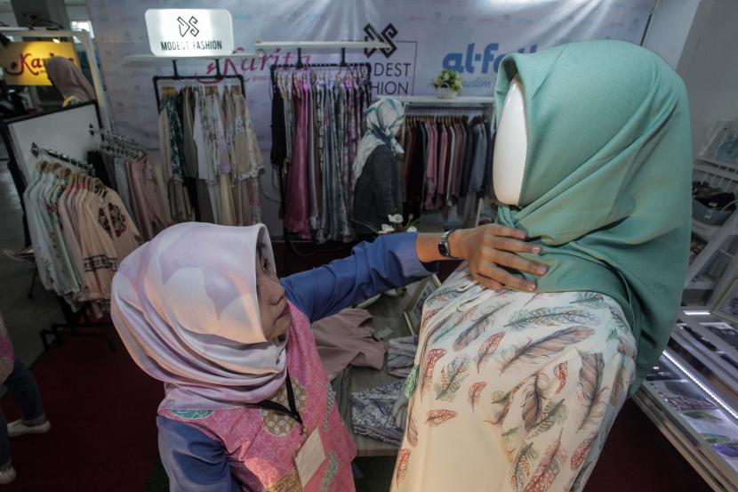 Ekonomi Halal - Penjaga stan menata produk fesyen halal yang dipamerkan pada Jogja Halal Fest (JHF) di Jogja Expo Centre, DI Yogyakarta.