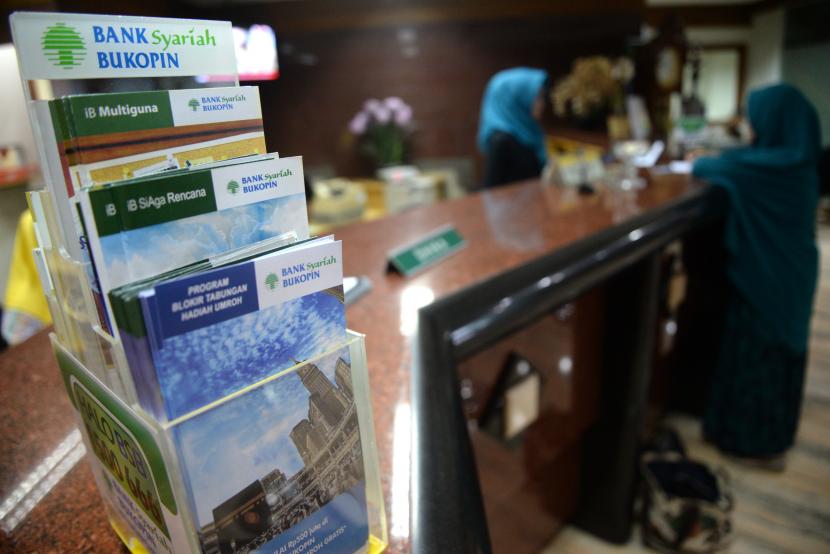 Petugas melayani transaksi nasabah di kantor layanan Bank Syariah Bukopin, Jakarta.