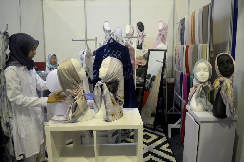 ilustrasi:industri halal - Karyawan menata produk fasion muslim yang di pamerakan dalam pameran industri halal. 