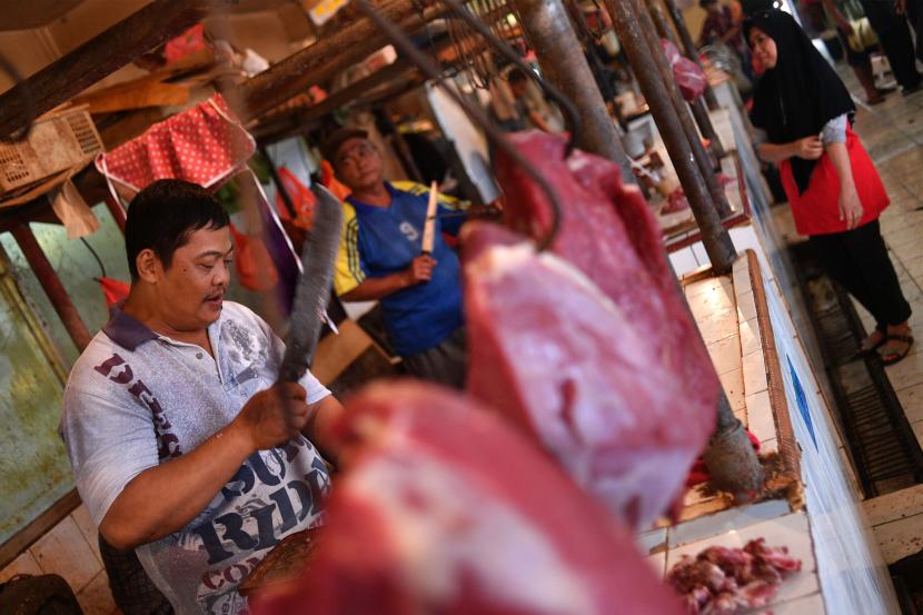 Pedagang memotong daging sapi yang dijual di pasar tradisional. ilustrasi