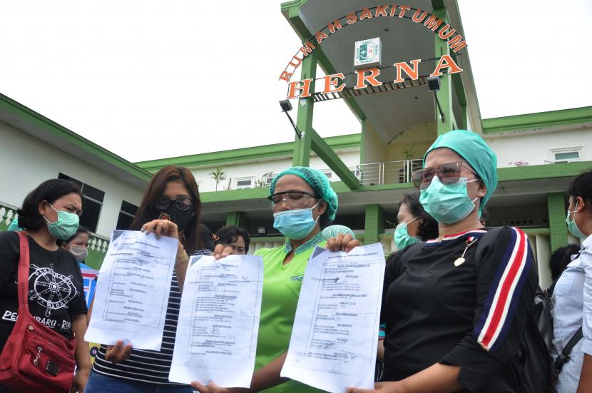 Ilustrasi:PHK - Sejumlah tenaga medis memperlihatkan surat karyawan yang sudah di PHK saat melakukan demo di Rumah Sakit Umum Herna Medan, Sumatera Utara, Jumat (10/7/2020).