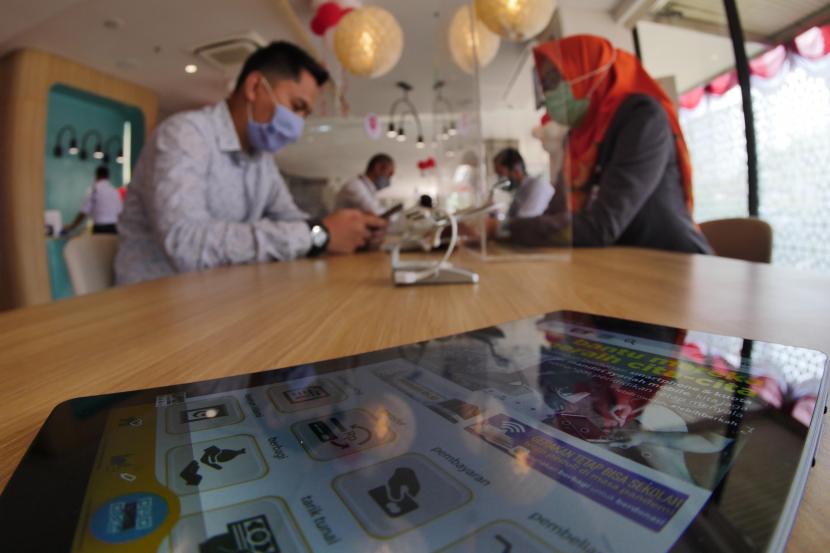 Pegawai bank syariah yariah menerangkan fitur bank kepada nasabah, di Jakarta, Senin (31/8). Kepala Eksekutif Pengawas Perilaku Usaha Jasa Keuangan, Edukasi dan Pelindungan Konsumen Otoritas Jasa Keuangan (OJK) Friderica Widyasari Dewi mengatakan aset keuangan syariah tumbuh 15 persen per Desember 2022.