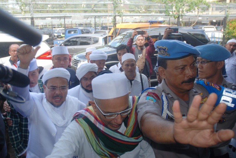 Imam Besar Front Pembela Islam (FPI) Habib Rizieq (kiri) mendatangi Mapolda Jabar untuk menjalani pemeriksaan, di Bandung, Jawa Barat, Kamis (12/7). 