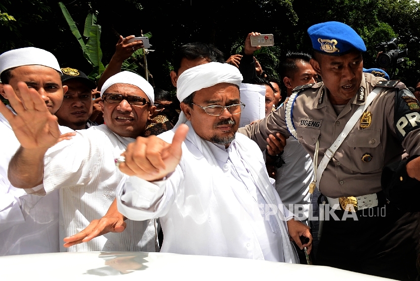 Imam Besar FPI Habib Rizieq Shihab (tengah) berjalan memasuki ruangan Direktorat Kriminal Khusus Polda Metro Jaya untuk menjalani pemeriksaan, Jakarta, Senin (23/1). 