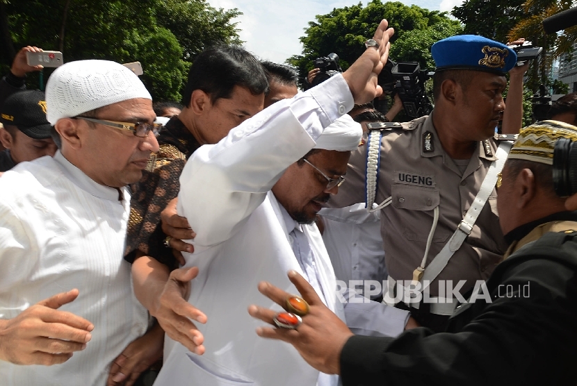 Imam Besar FPI Habib Rizieq Shihab (tengah) berjalan memasuki ruangan Direktorat Kriminal Khusus Polda Metro Jaya untuk menjalani pemeriksaan, Jakarta. (Ilustrasi)