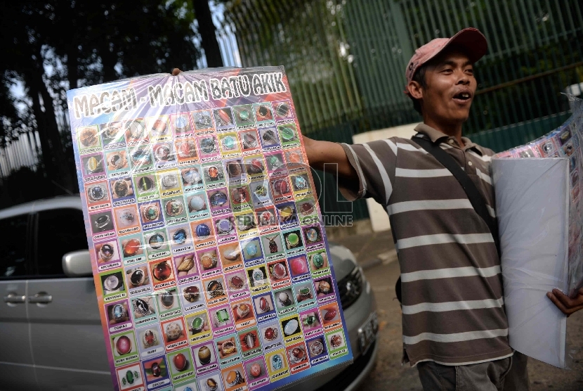 Imbas Demam Batu Akik. Penjual menawarkan poster bergambar aneka batu akik di Jalan Denpasar Raya, Jakarta, Rabu (8/4).