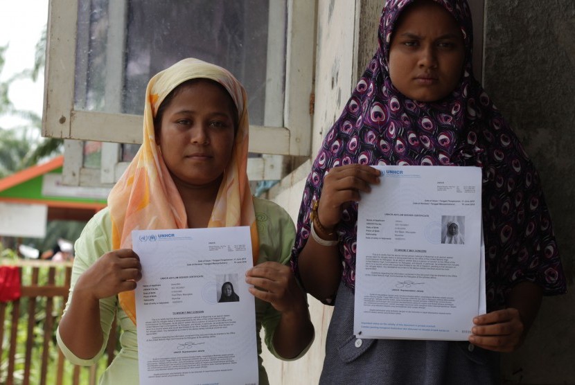 Imigran Etnis Rohingya asal Myanmar memperlihatkan sertifikat pencari suaka di tempat penampungan sementara Desa Bayeun, Kecamatan Rantoe Seulamat, Aceh Timur, Aceh, Senin (22/6). Badan PBB untuk Pengungsi (UNHCR) mengutarakan keprihatinan atas berlanjutnya aksi deportasi oleh Malaysia terhadap para pencari suaka dari Myanmar.