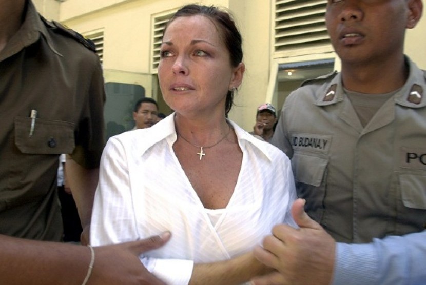 In a photo file, Schapelle Leigh Corby (center), who is currently serving 20 years in an Indonesian prison for drug smuggling, is escorted by police officers after her appeal hearing at the district court in Denpasar, Bali, Indonesia. A court official says