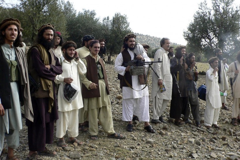 In this file image taken on Oct. 4, 2009, Pakistan's new Taliban leader Hakimullah Mehsud, center, operates light machine gun with his comrades in Sararogha in Pakistani tribal area of South Waziristan along Afghanistan border. Intelligence officials said 