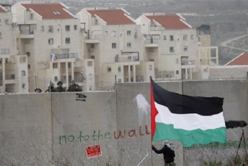 A protester waves a Palestinian flag during a protest against Israel's separation barrier in Ramallah. (file photo)