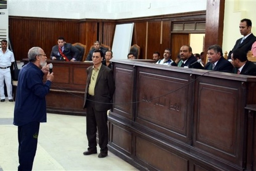 In this May 18, 2014 file photo, Muslim Brotherhood leader Mohammed Badie (left) speaks before judge after getting out of a defendant cage during his trial in Cairo, Egypt. 