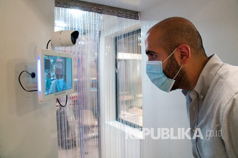 100 Persen PNS Dubai Kembali Kerja di Kantor. Seorang pekerja memeriksa sistem alat pengecekan suhu tubuh dan bilik disinfektan di Dubai, Uni Emirat Arab.