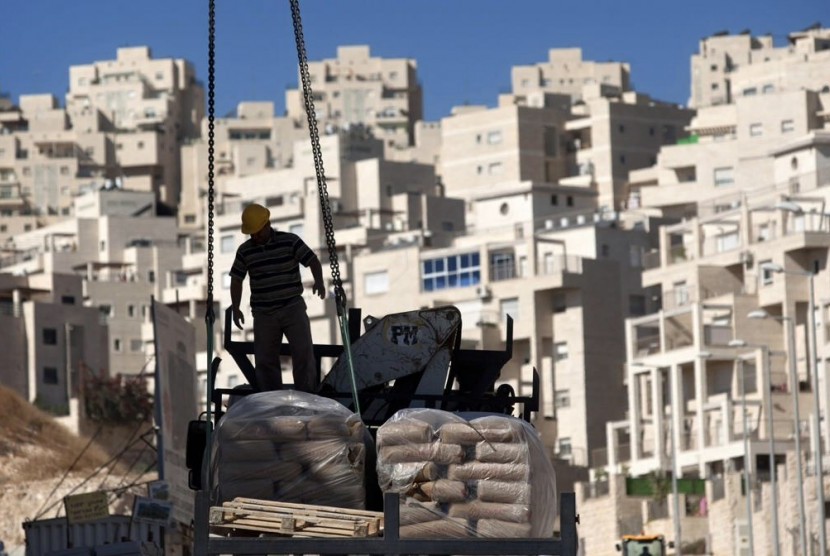 In this Nov. 2, 2011 file photo, a construction worker works on a new housing unit in the east Jerusalem neighborhood of Har Homa. 