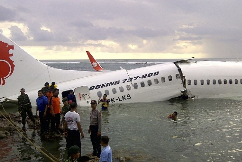 In this photo released by Indonesia's National Rescue Team, rescuers stand near the wreckage of a crashed Lion Air plane in Bali, Indonesia on Saturday, April 13, 2013. 