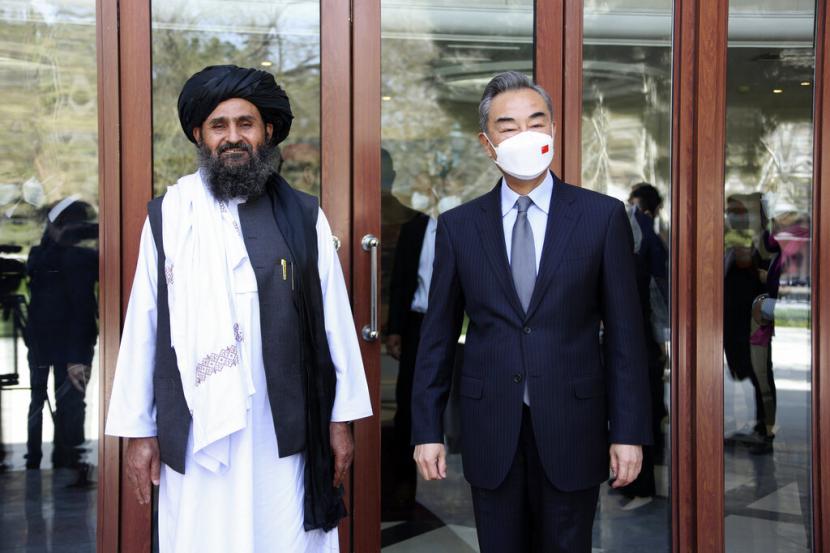 In this photo released by Xinhua News Agency, Chinese Foreign Minister Wang Yi, right, stands next to Mullah Abdul Ghani Baradar, acting deputy prime minister of the Afghan Taliban