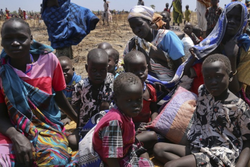 In this photo taken Saturday, Feb. 25, 2017 and released by the World Food Programme (WFP), a family waits for food assistance to be distributed in Thonyor, Leer County, one of the areas in which famine has been declared, in South Sudan.