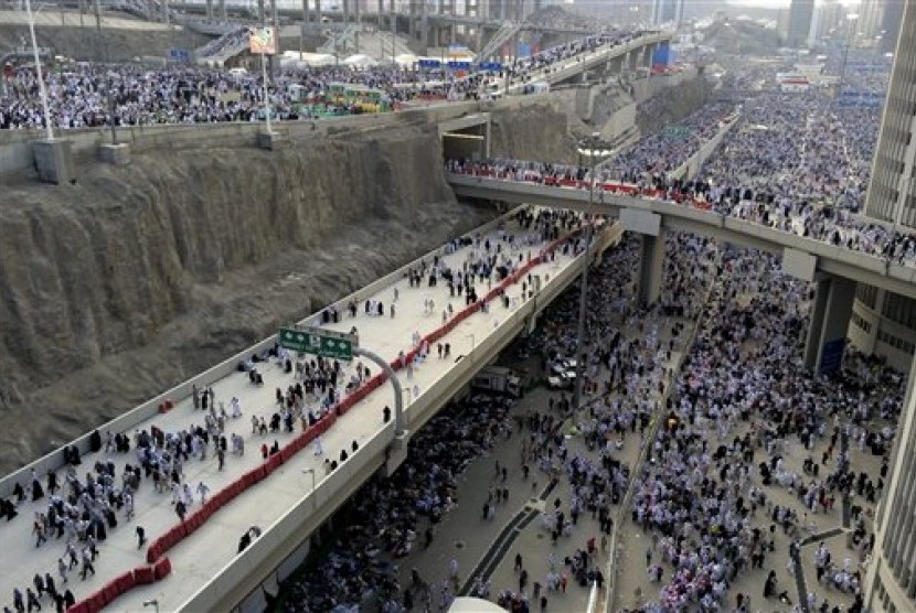 In this Sunday, Oct. 5, 2014 photo, thousands of Muslim pilgrims make their way to throw stones at a pillar, symbolizing the stoning of Satan during the annual pilgrimage, known as the hajj, outside of Mecca, Saudi Arabia. 