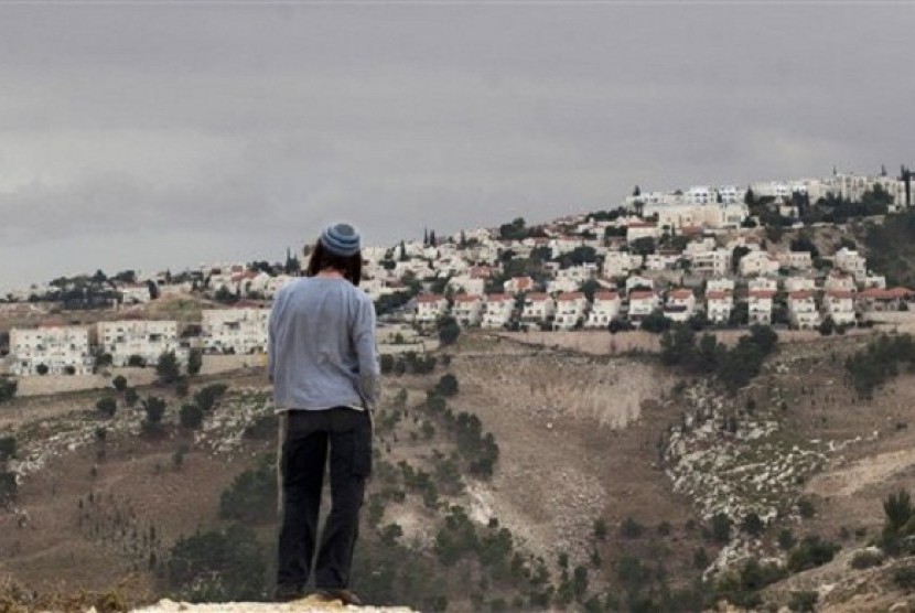 In this Wednesday, Dec. 5, 2012 file photo A Jewish settler looks at the West bank settlement of Maaleh Adumim, from the E-1 area on the eastern outskirts of Jerusalem. 