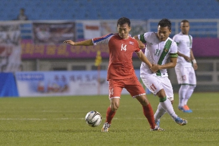 Indonesia Dedi Kusnandar (kanan) berusaha merebut bola dari pesepak bola Korea Utara Ilgwang Yun.