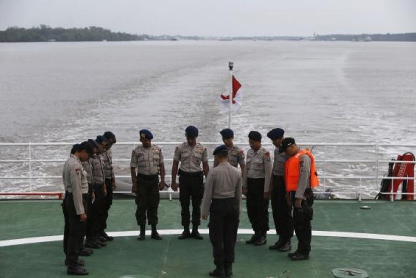 Indonesia policemen pray on deck of SAR ship KN Purworejo during a search operation for passengers onboard AirAsia flight QZ8501, in Java Sea, Indonesia January 3, 2015.
