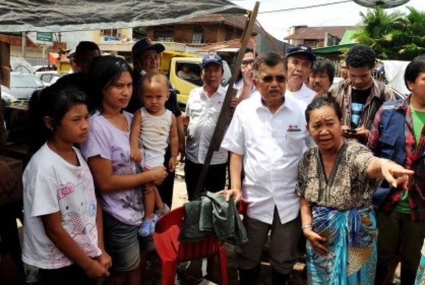 Indonesia Red Cross chief, M Jusuf Kalla (wearing glasses) visits the flood victims in Manado, nirth Sulawesi, on Monday.