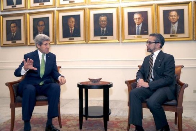 Indonesia's Foreign Minister Marty Natalegawa  (right) talks with visiting US Secretary of State John Kerry at the Foreign Ministry office before a meeting in Jakarta February 17, 2014. 