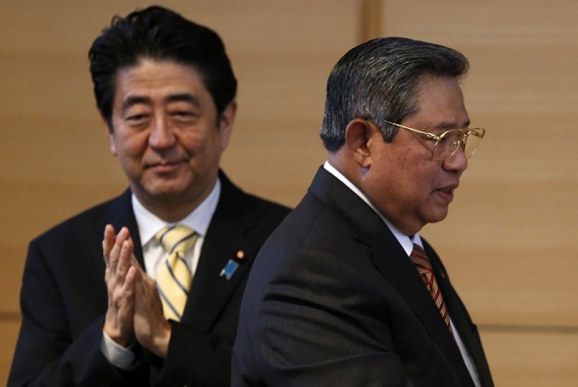 Indonesia's President Susilo Bambang Yudhoyono (left) walks as Japan's Prime Minister Shizo Abe applauds after delivering a speech at his lecture event in Tokyo December 13, 2013. Yudhoyono is in Japan to attend summit meetings between Japanese and ASEAN l