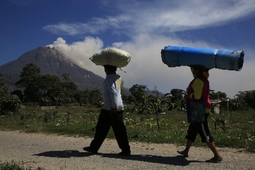 INDONESIA-VOLCANO/ - Villagers walk back home after living in a temporary shelter for the last two months, as Mount Sinabung spews ash, in Karo regency, Indonesia