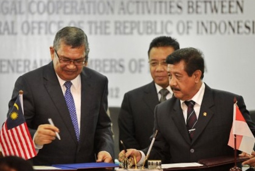 Indonesian Attorney General, Basrief Arief (right) exchanges document of MoU with Malaysian Attorney General, Tan Sri Abdul Gani Patail, in Jakarta on Monday.  