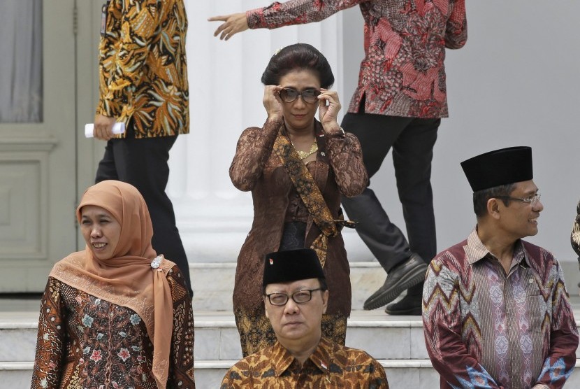Indonesian Maritime and Fisheries Minister Susi Pudjiastuti, center, adjusts her sunglasses as she prepares for a photo session after the inauguration ceremony for the newly appointed Cabinet members at the presidential palace in Jakarta, Indonesia, Monday