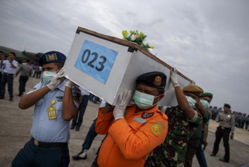 Indonesian military personnel carry a casket containing the remains of a passenger onboard AirAsia flight QZ8501, recovered off the coast of Borneo, at a military base in Surabaya January 3, 2015.