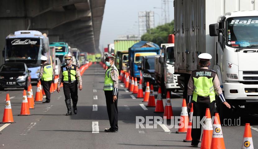   Polisi melakukan pemeriksaan kendaraan yang meninggalkan wilayah Jabodetabek melaui jalan tol Jakarta-Cikampek, Jumat (24/4).