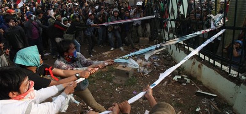 Indonesian protesters pull down the fence of the parliament building during a protest against the government's plan to raise fuel prices, in Jakarta, Indonesia, Friday.