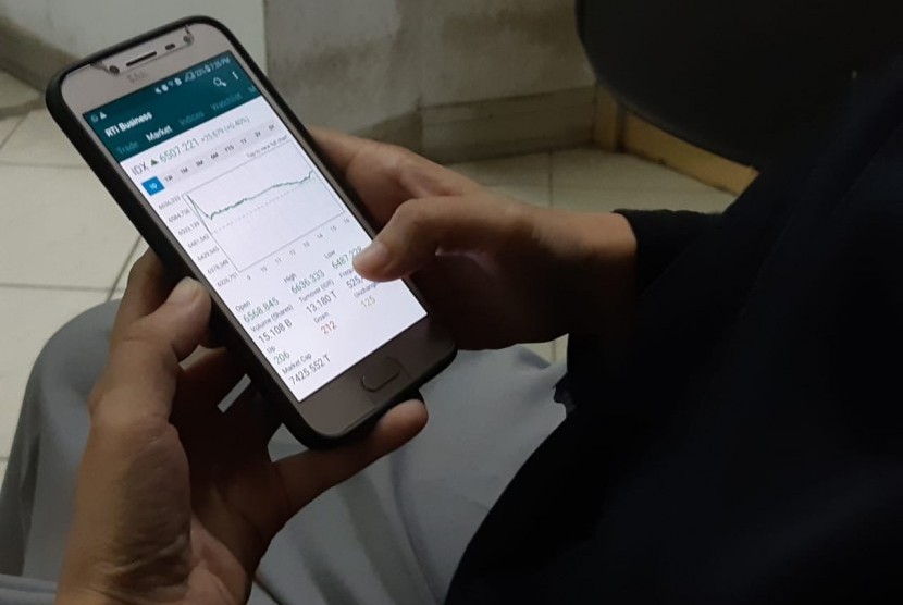 Investor memantau pergerakan Indeks Harga Saham Gabungan (IHSG) melalui ponsel pintar, Kamis (18/4).