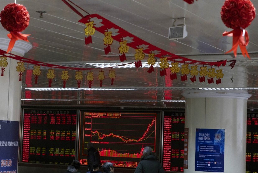 Investor mengecek pergerakan saham di salah satu perusahaan sekuritas di Beijing (foto ilustrasi). Pasar saham China dibuka anjlok pada perdagangan perdana pasca libur Imlek 2020.